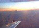 頭を雲の上に出す、夕焼けの富士山。帰りの飛行機から。